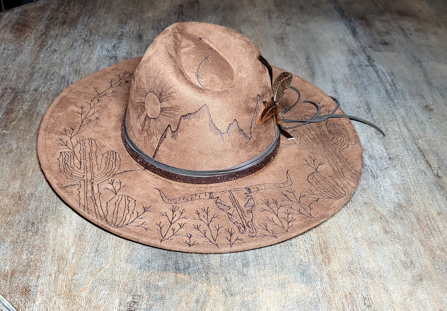 Introducing "Miranda" our desert sun scape suede fedora hat. Hand is burned on top and under her brim, fully adjustable