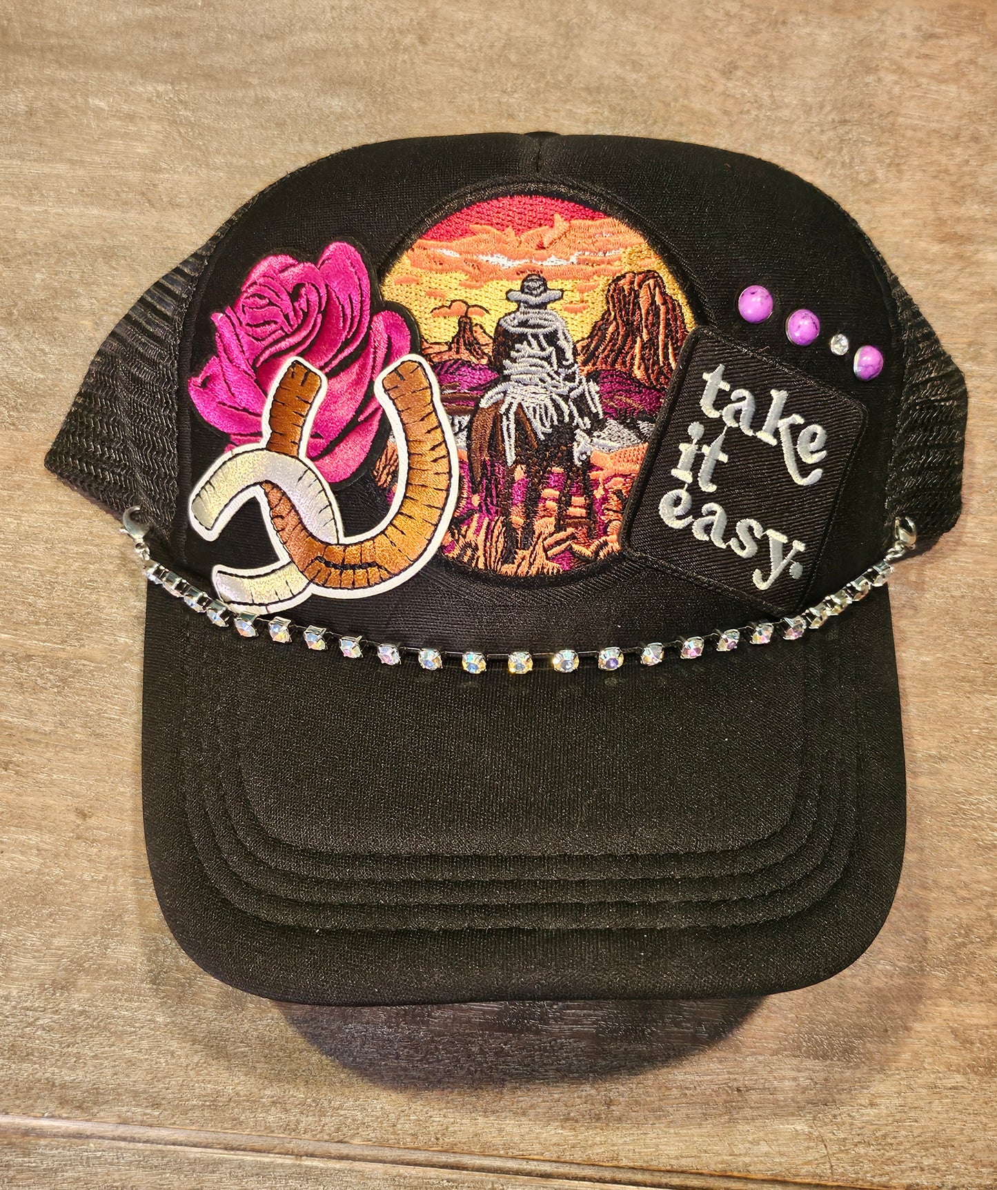 Custom "Take it easy" trucker hat with western style patches and accented with studs and a rhinestone hat chain