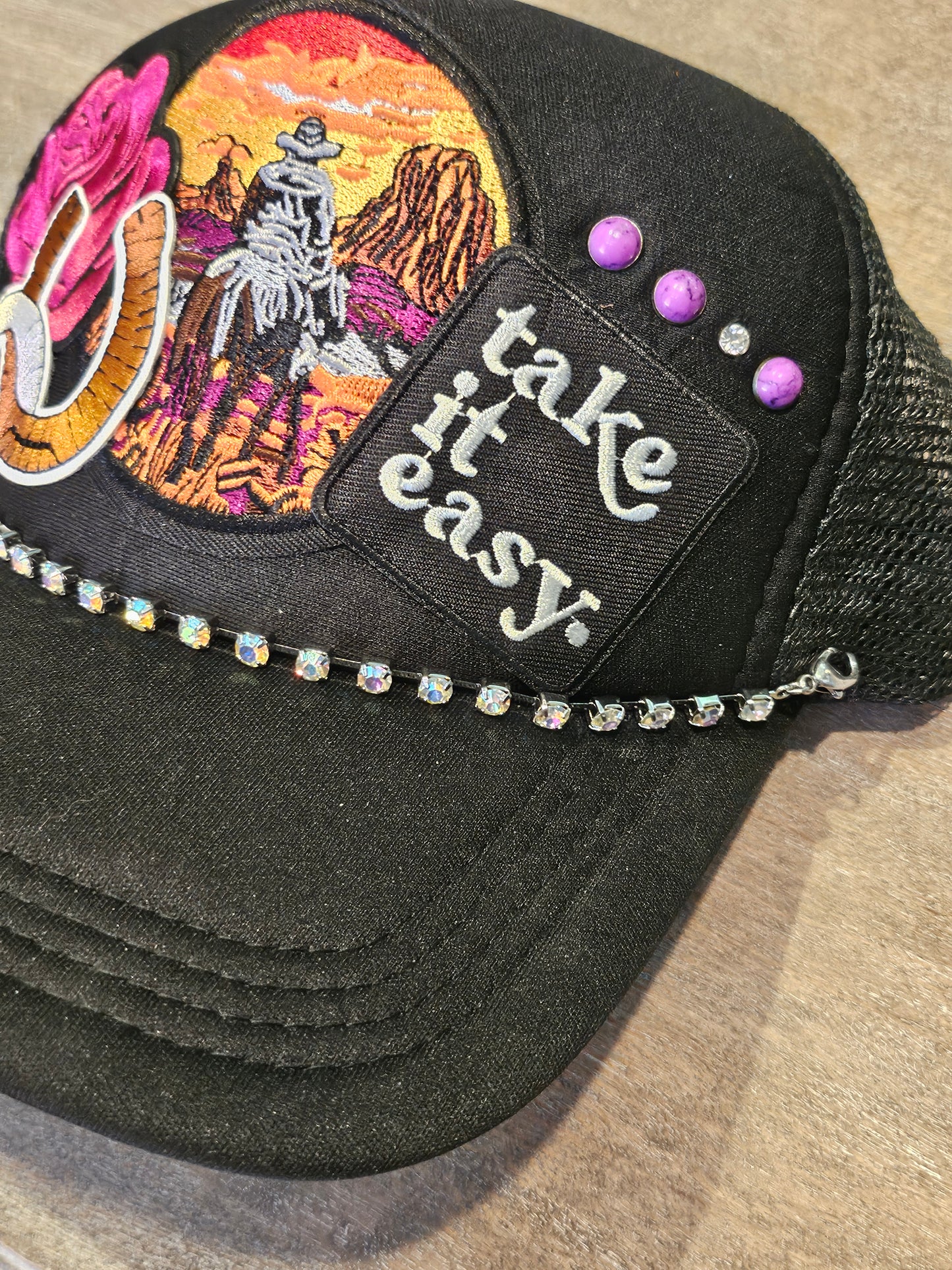 Custom "Take it easy" trucker hat with western style patches and accented with studs and a rhinestone hat chain