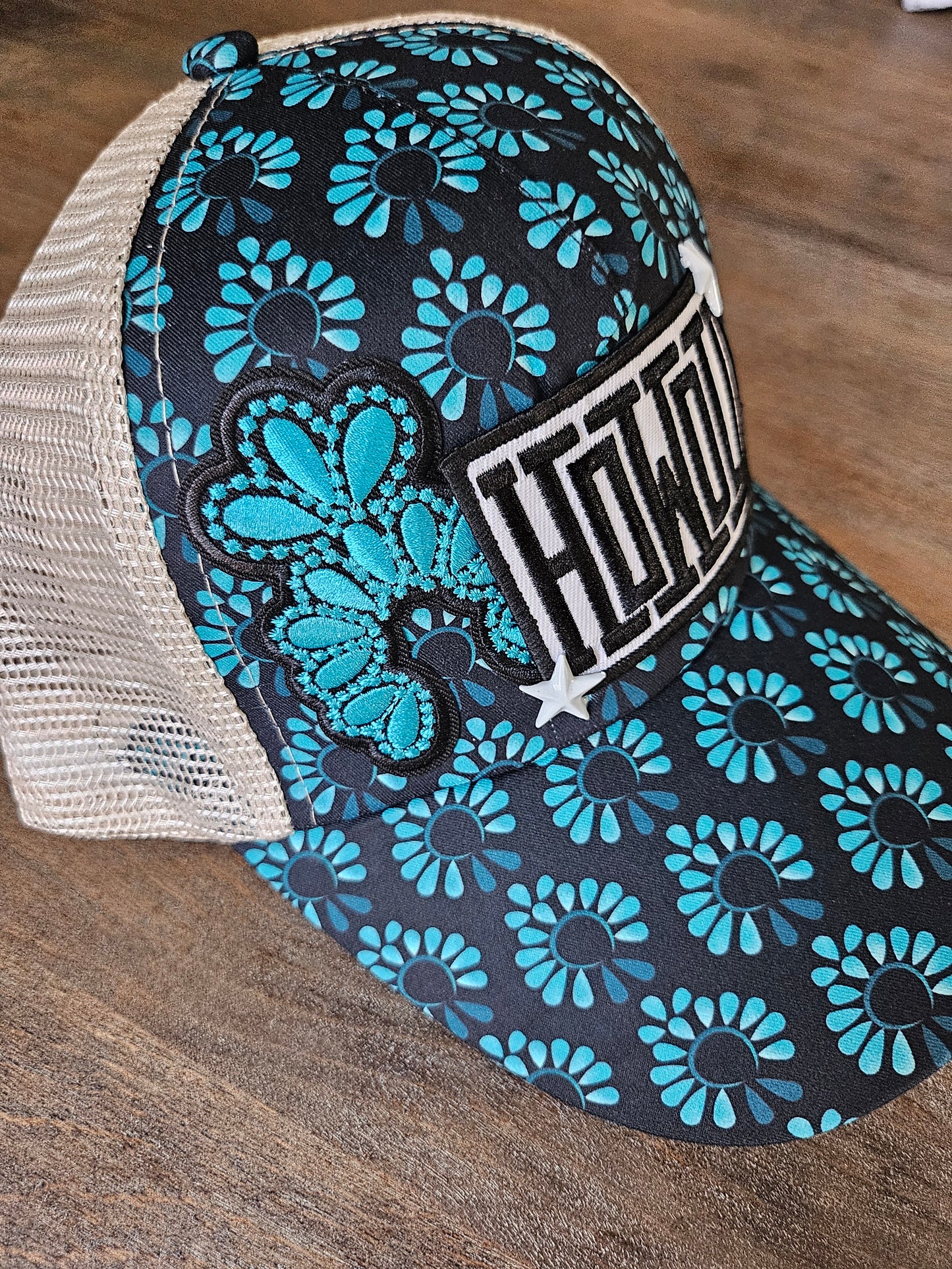 Trucker ponytail hat is custom with embroidered turquoise squash blossom and "Howdy" patches and star studs