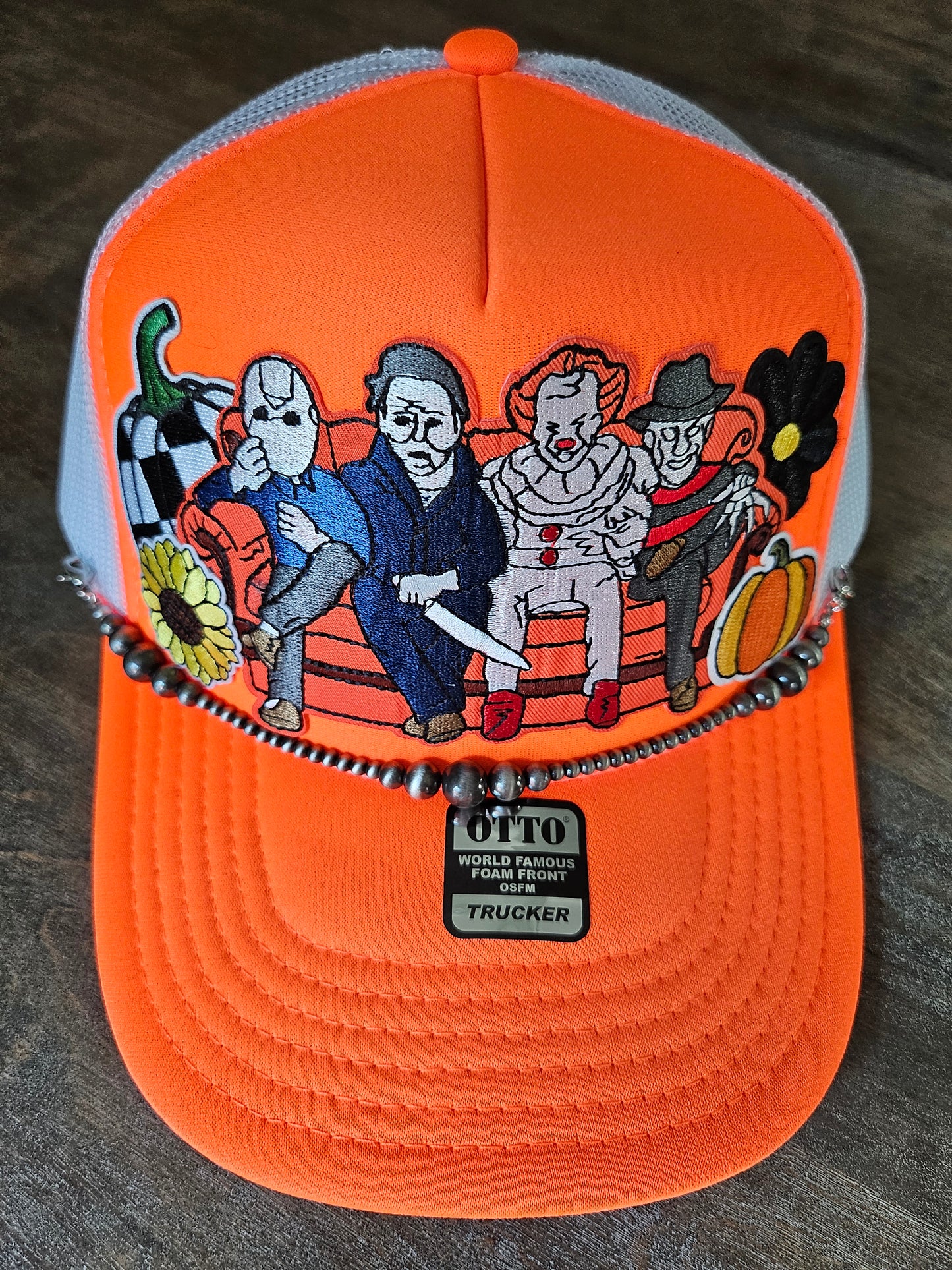 Trucker hat with orange Halloween retro villains and a Navajo pearl hat chain