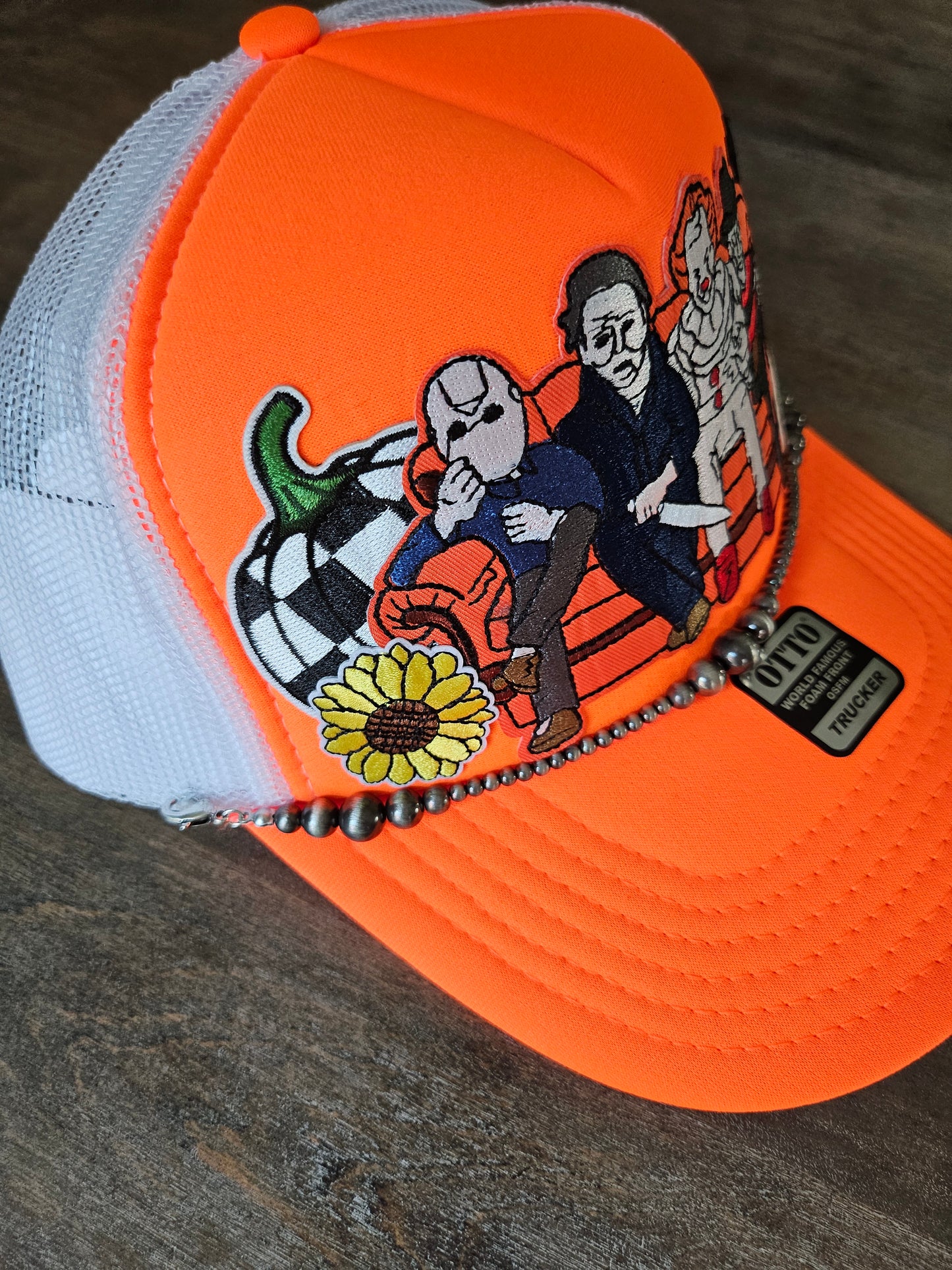 Trucker hat with orange Halloween retro villains and a Navajo pearl hat chain