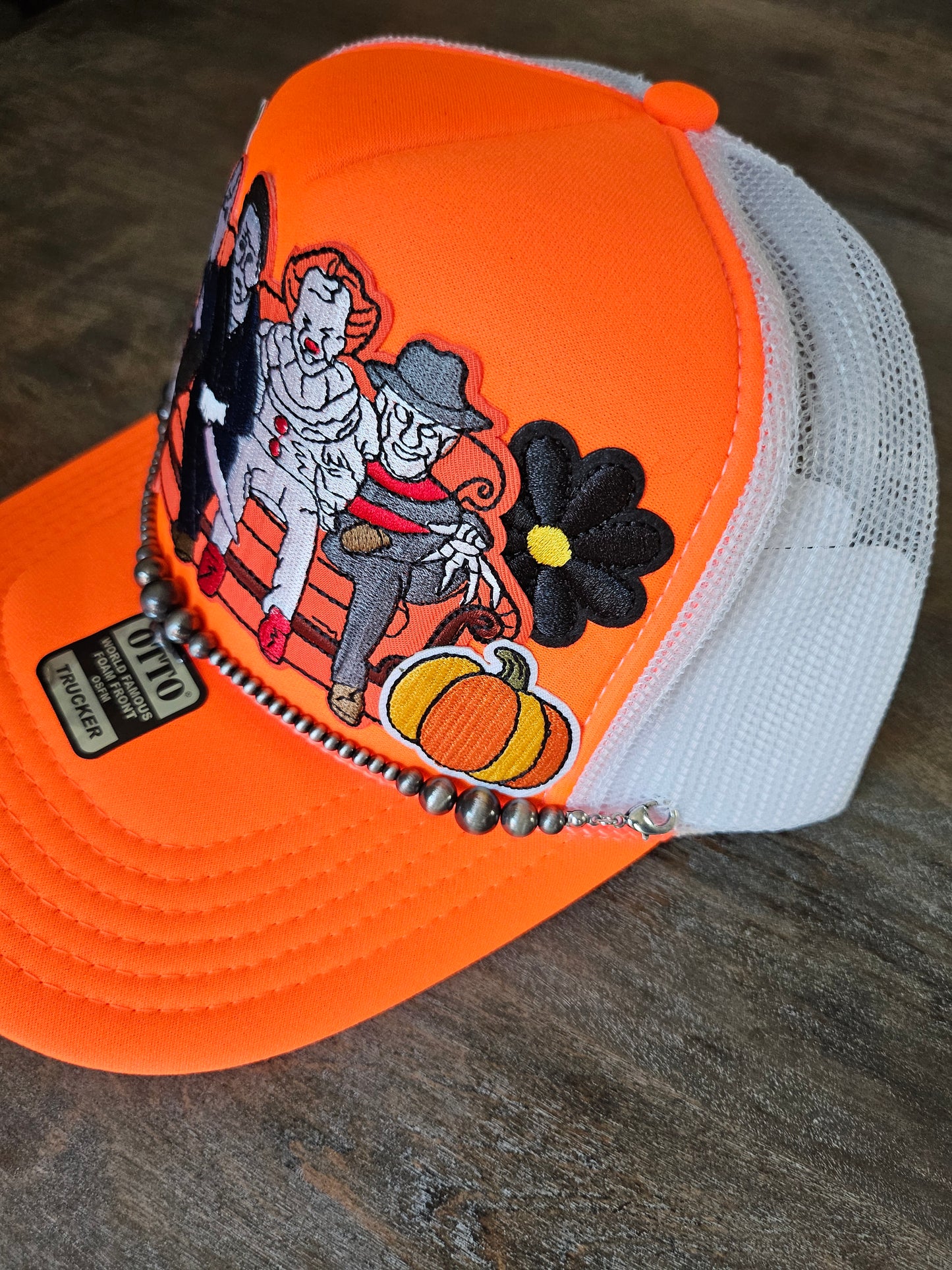 Trucker hat with orange Halloween retro villains and a Navajo pearl hat chain