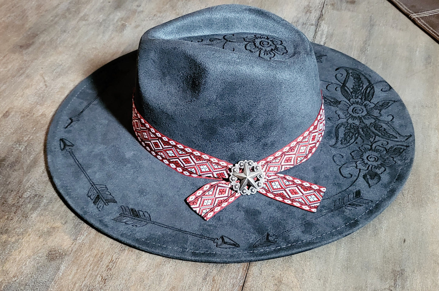 Grey suede burned cowboy hat fedora with the saying "forget the first arrow, only the next one counts"